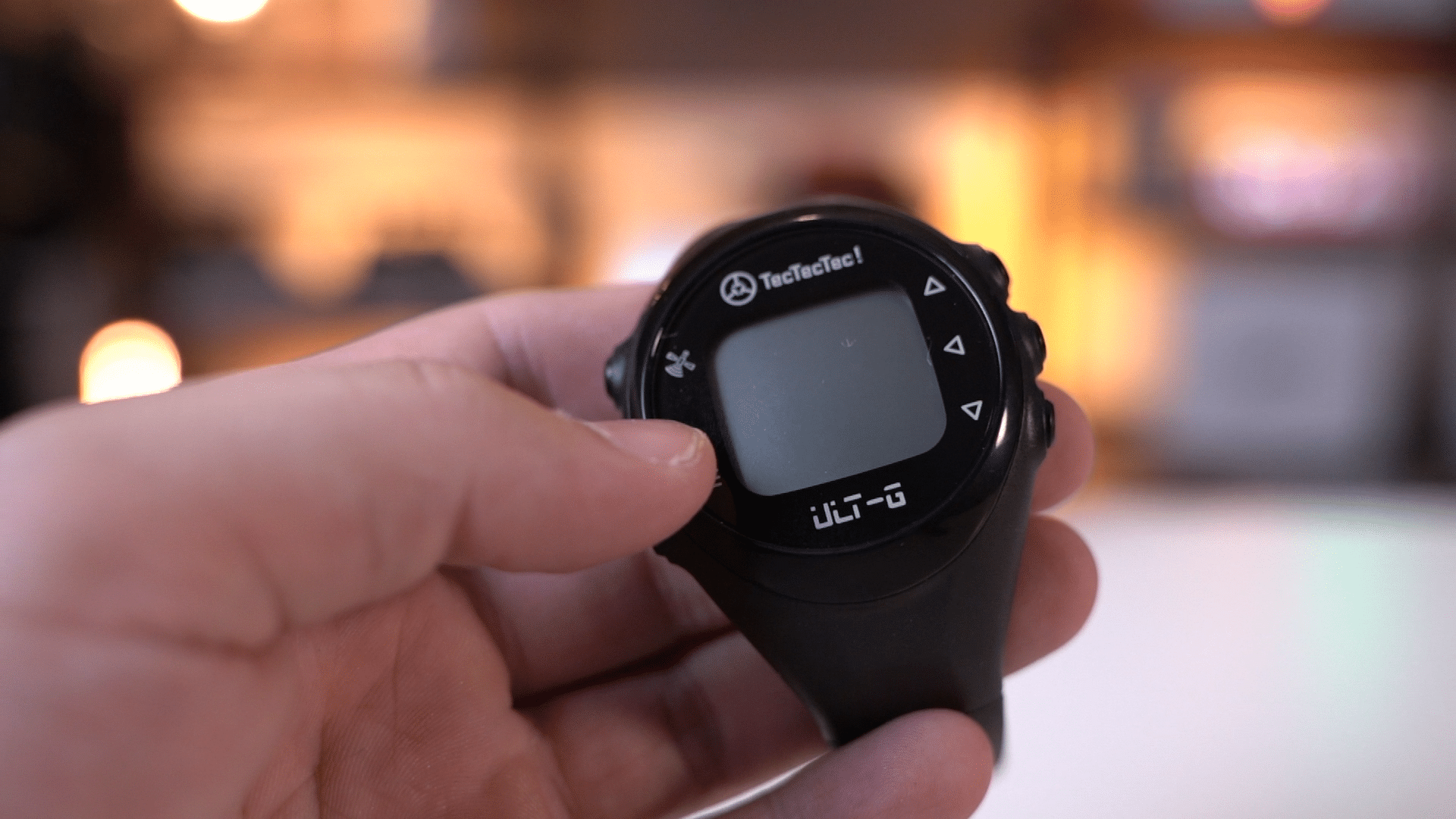 Hand holding black TecTecTec digital watch