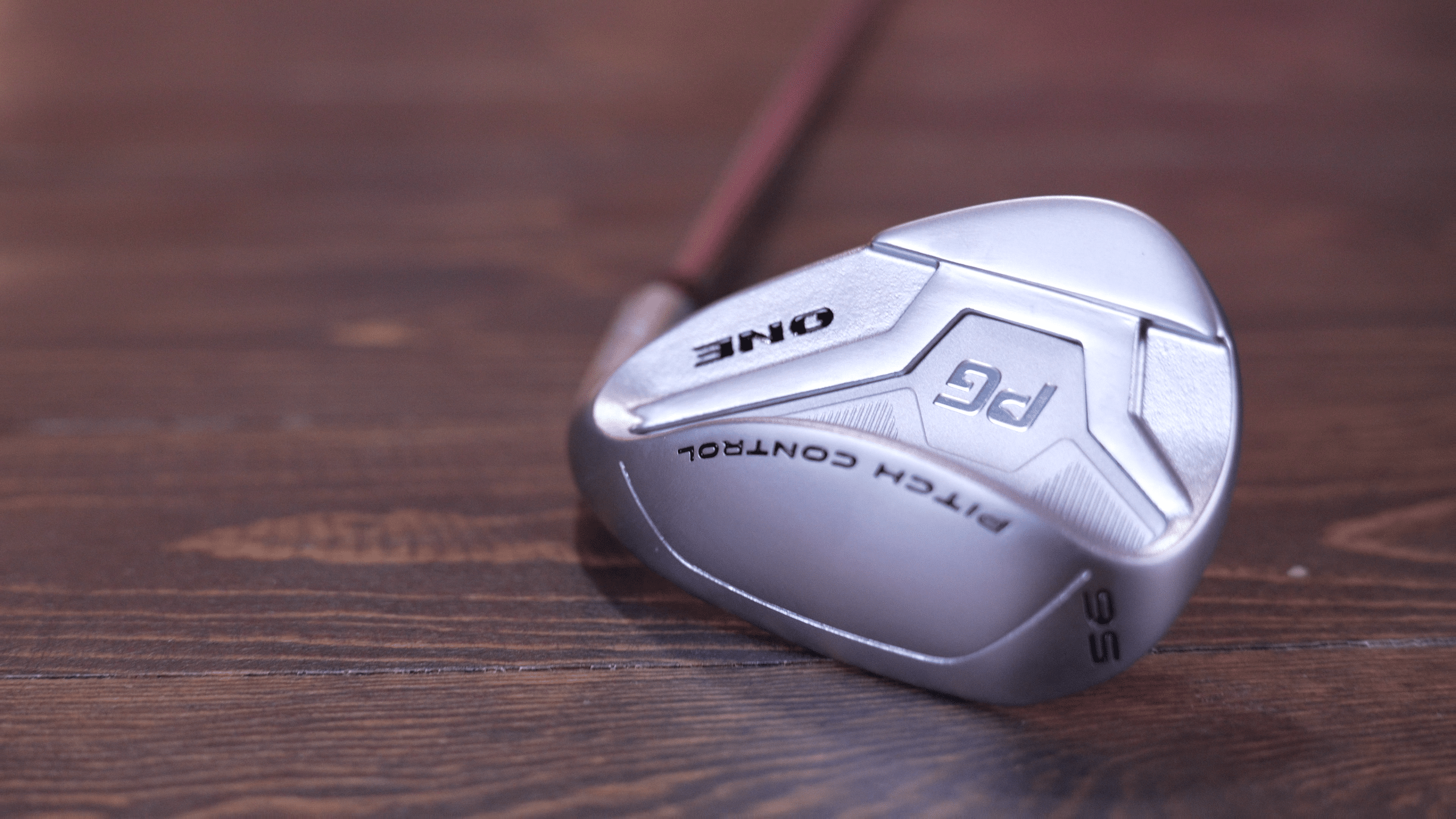 Silver golf club on wooden surface