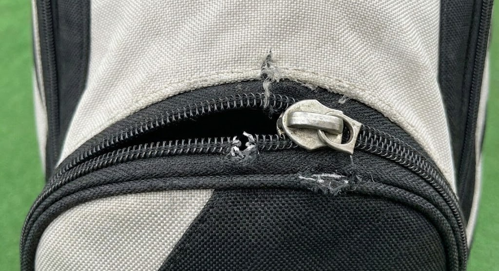 Damaged zipper on black and white bag
