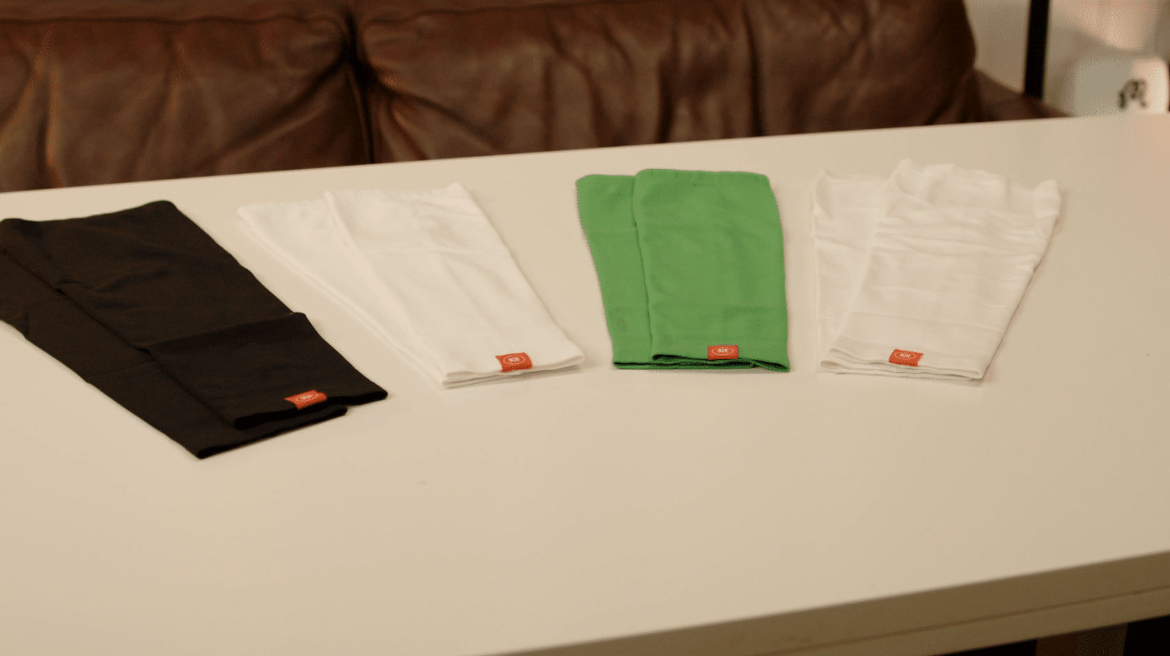 Four folded leggings on white table