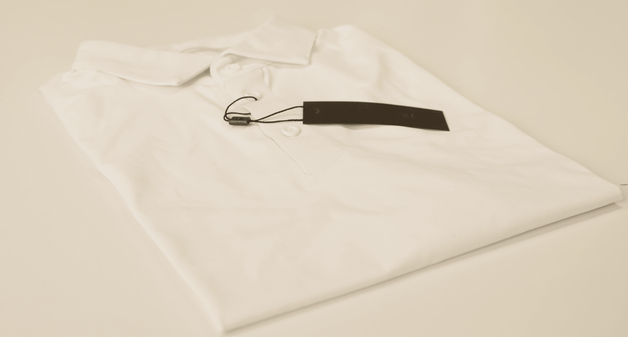 Folded white polo shirt with attached brand tag