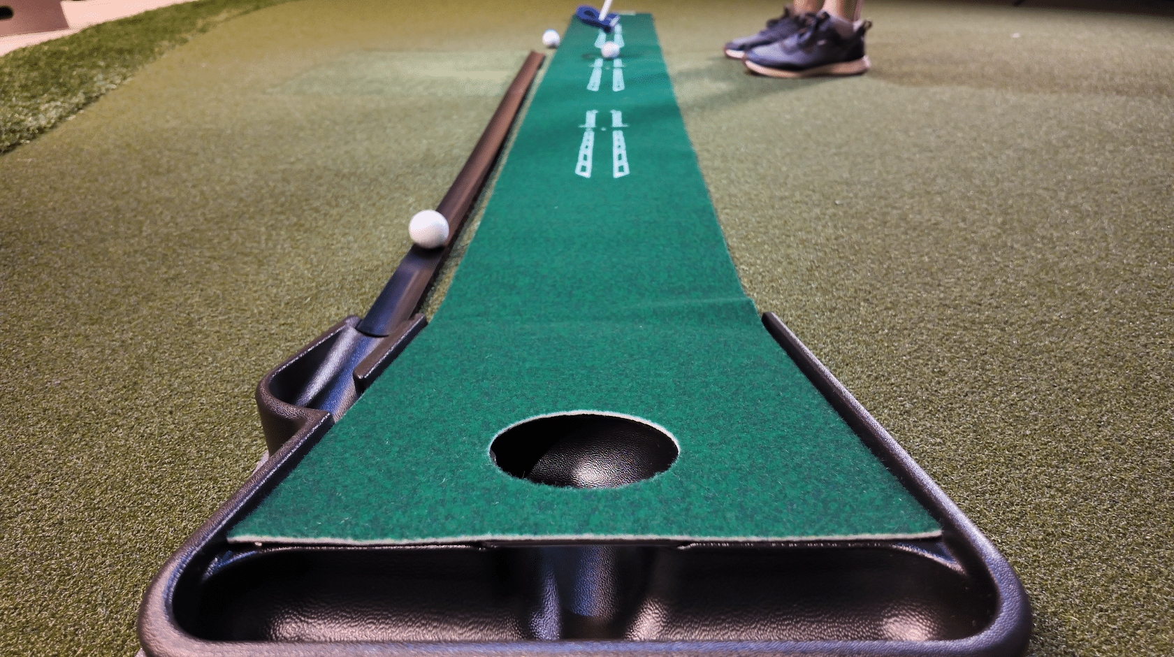 Indoor golf putting mat with ball and hole