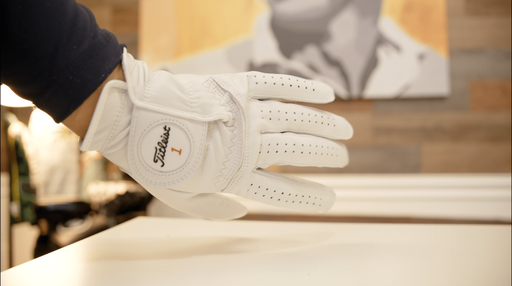 Hand wearing white Titleist golf glove
