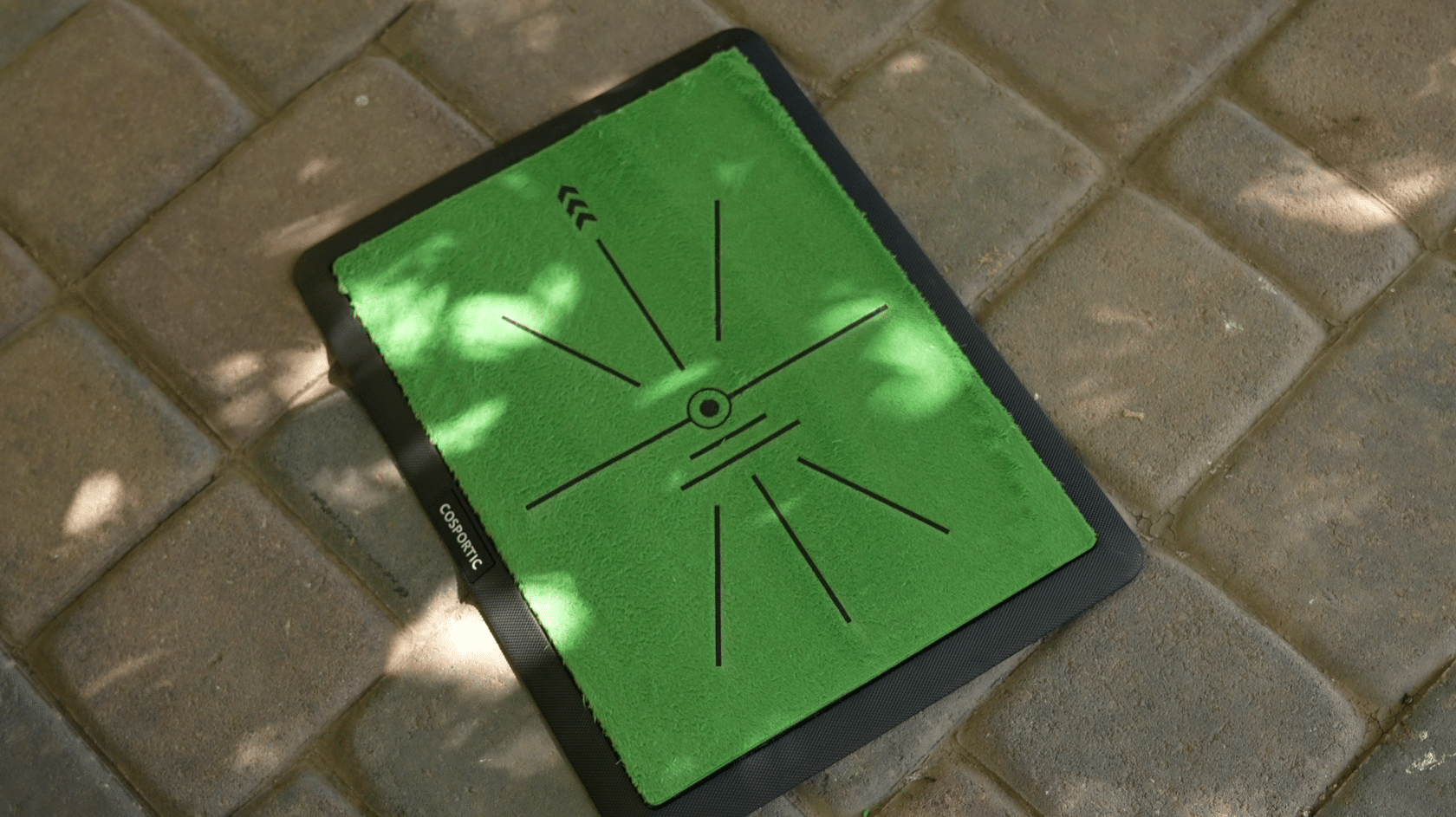 Green golf training mat on stone patio