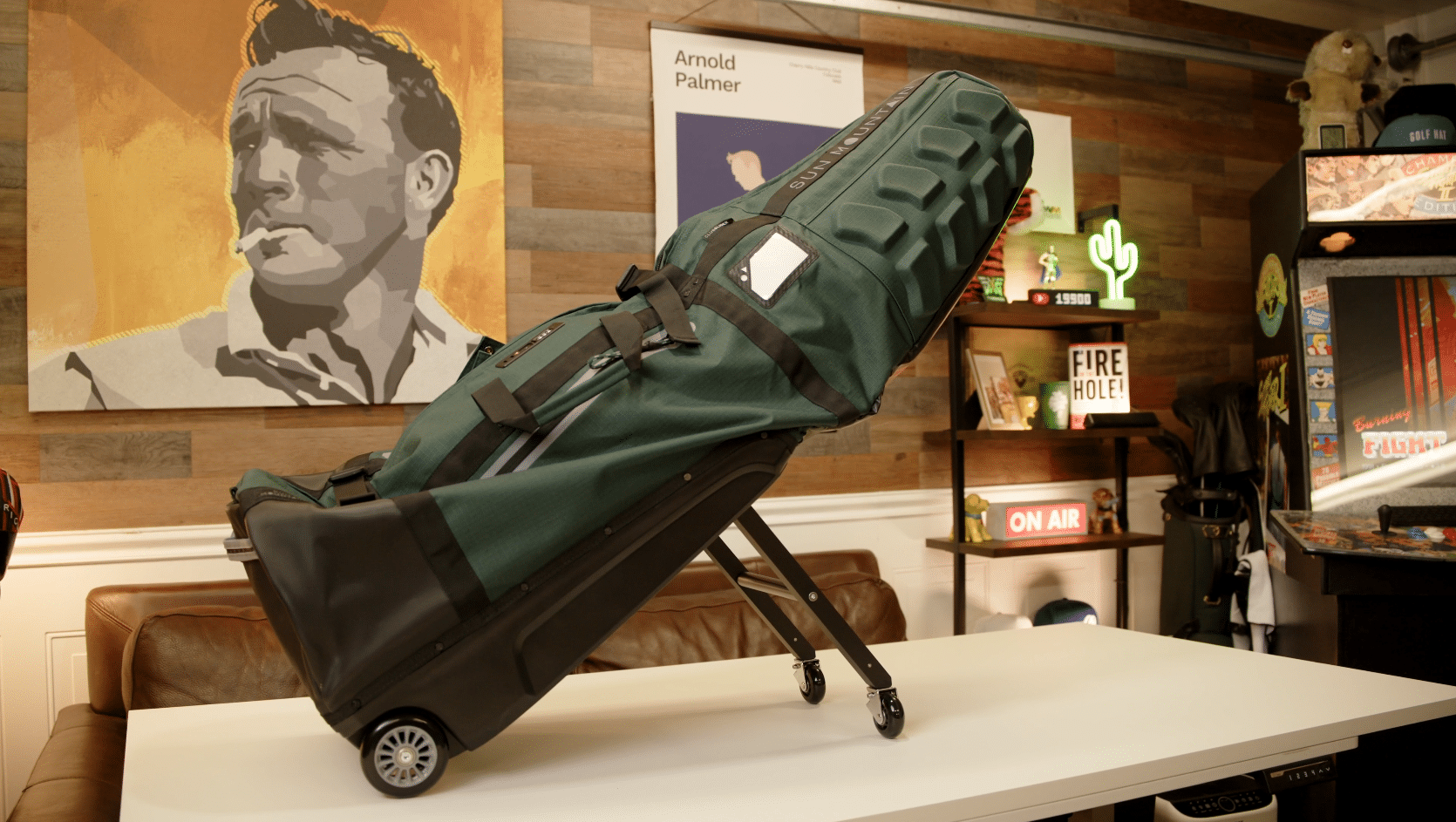 Green golf travel bag on wheeled base indoors