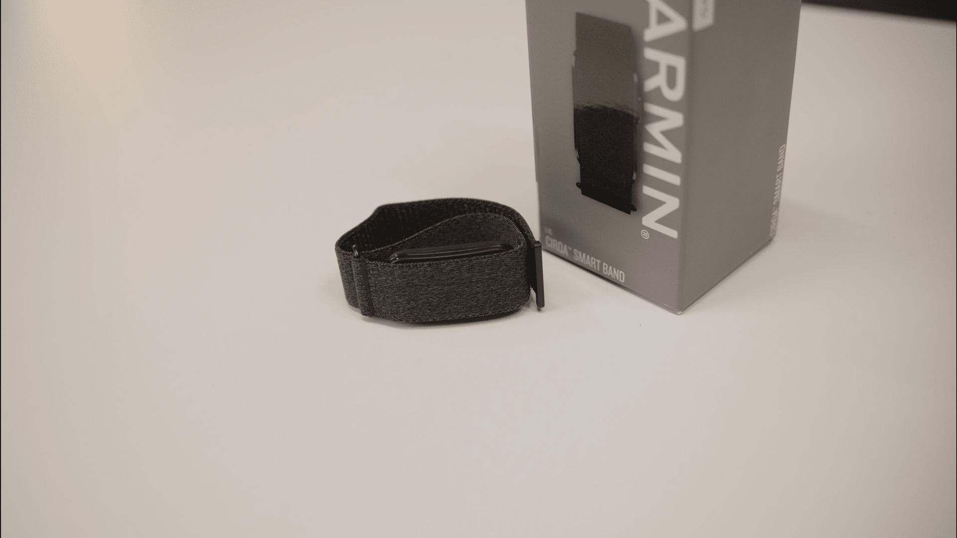 Garmin Cirqa smart band beside retail packaging