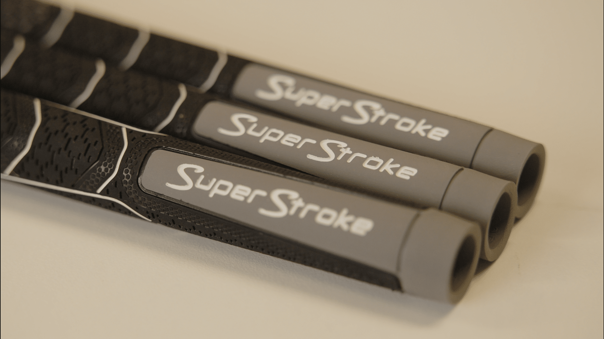Three Super Stroke golf club grips arranged side by side