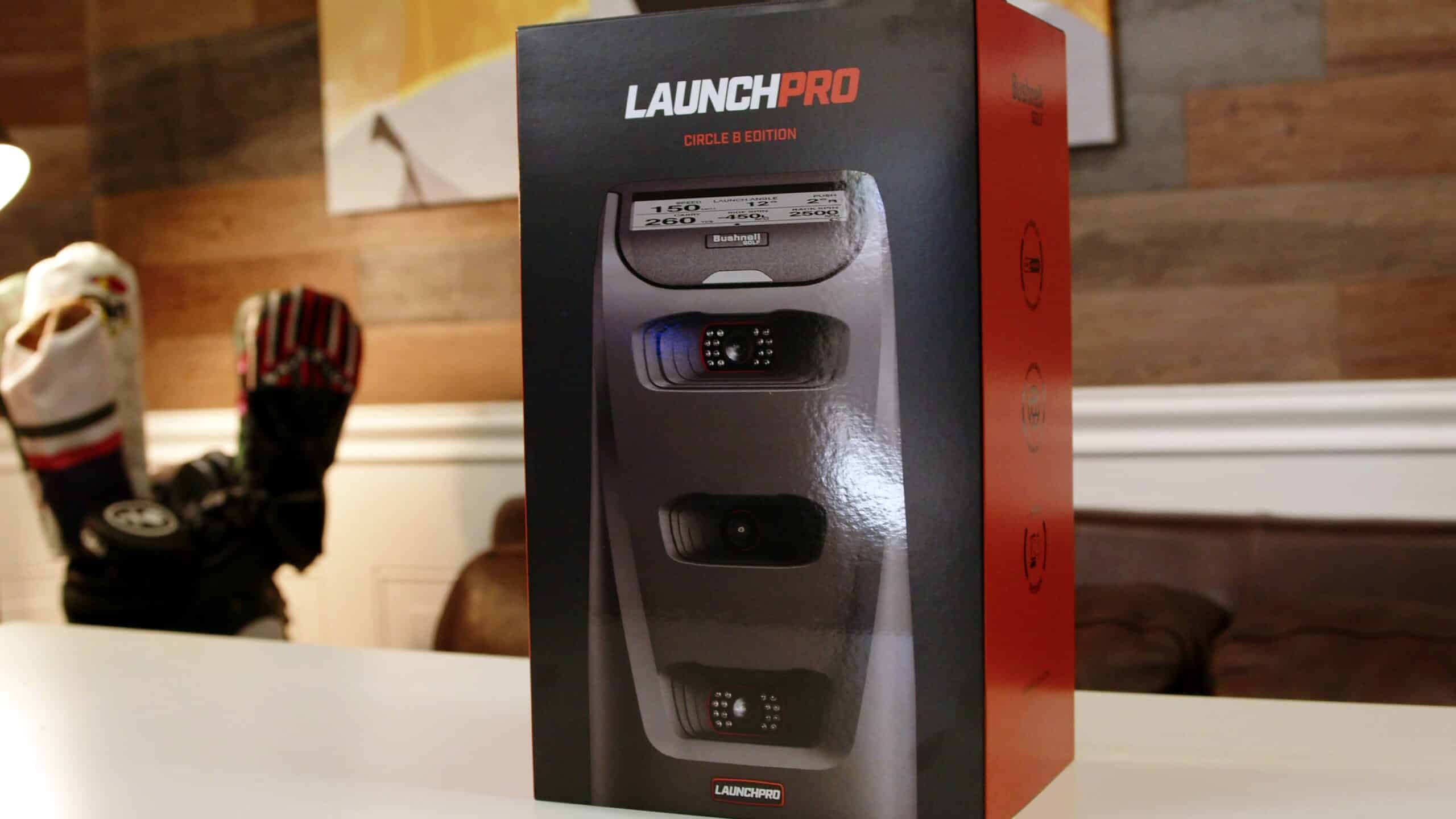 The Bushnell Launch Pro Circle B Edition launch monitor standing beside its retail box